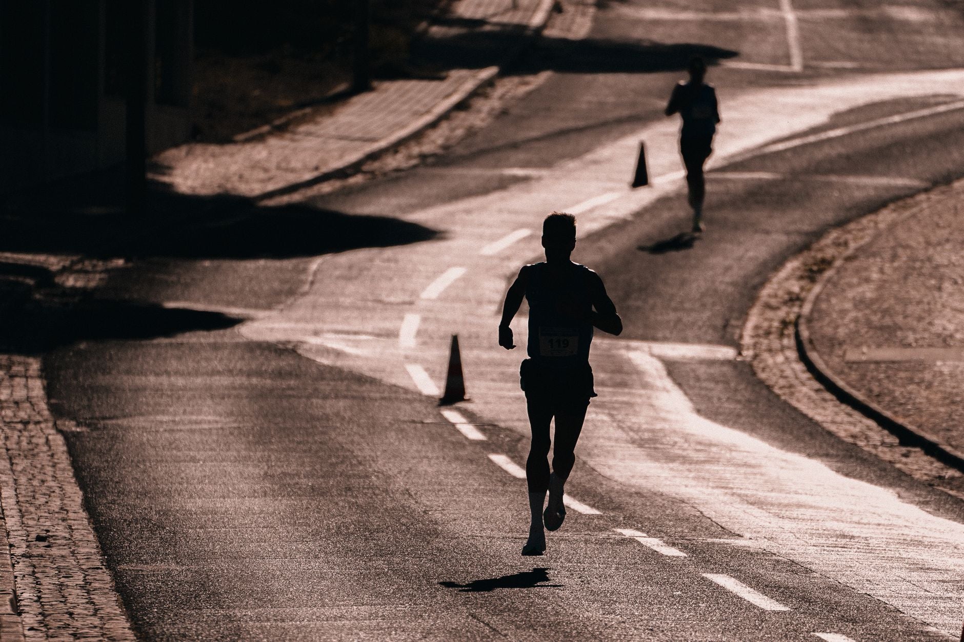 silhouette runner on a road during race training at dusk