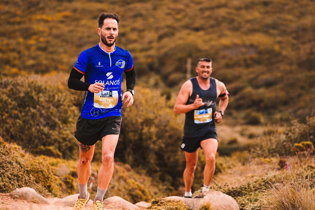 two trail runners moving through a forest trail during training