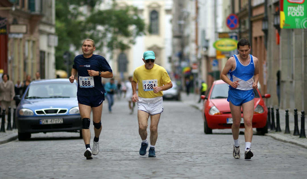 Three athletes running in a city marathon, showcasing urban sports culture.