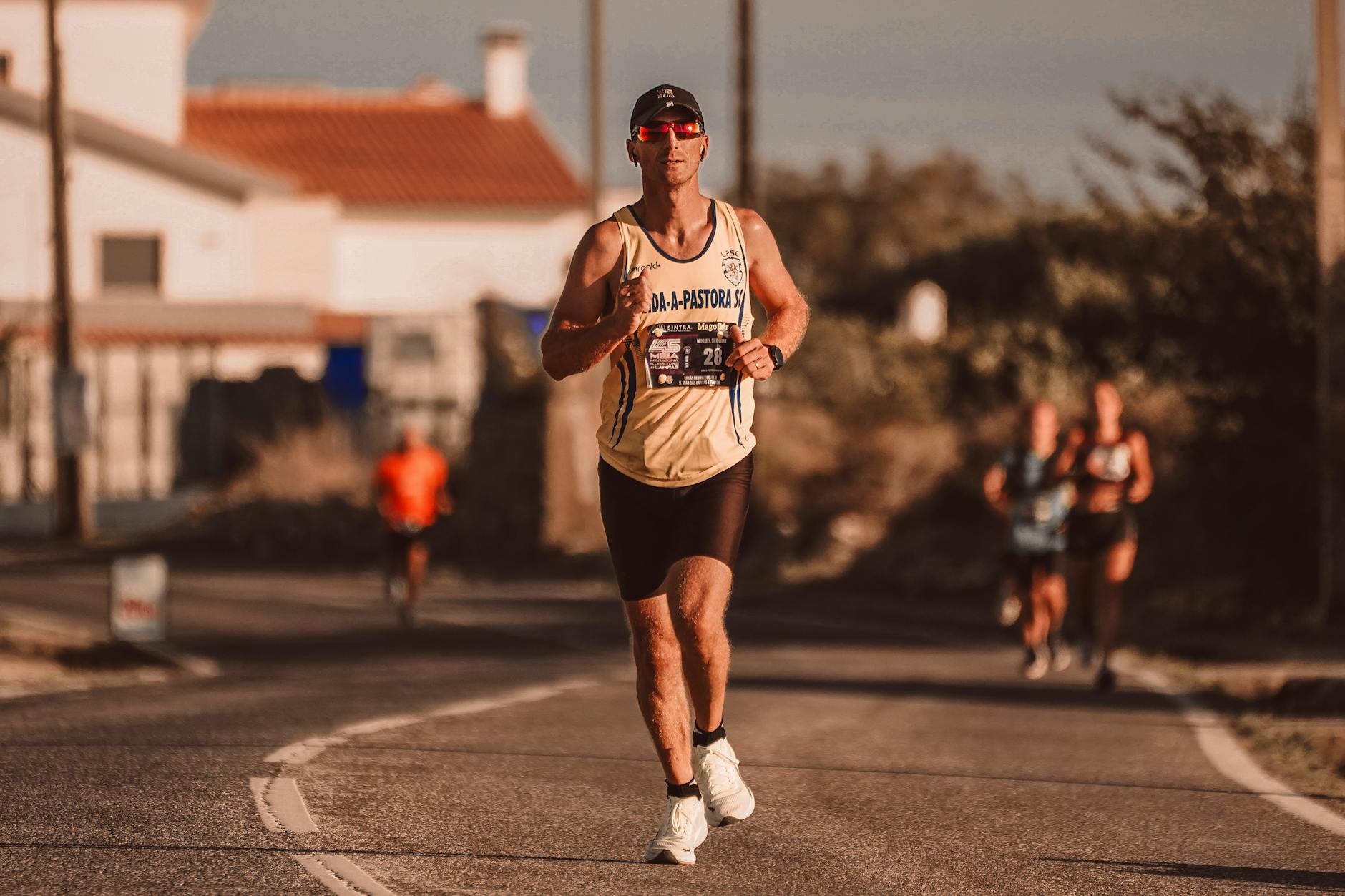 Focused runner in sportswear participating in a city marathon under the warm sun.