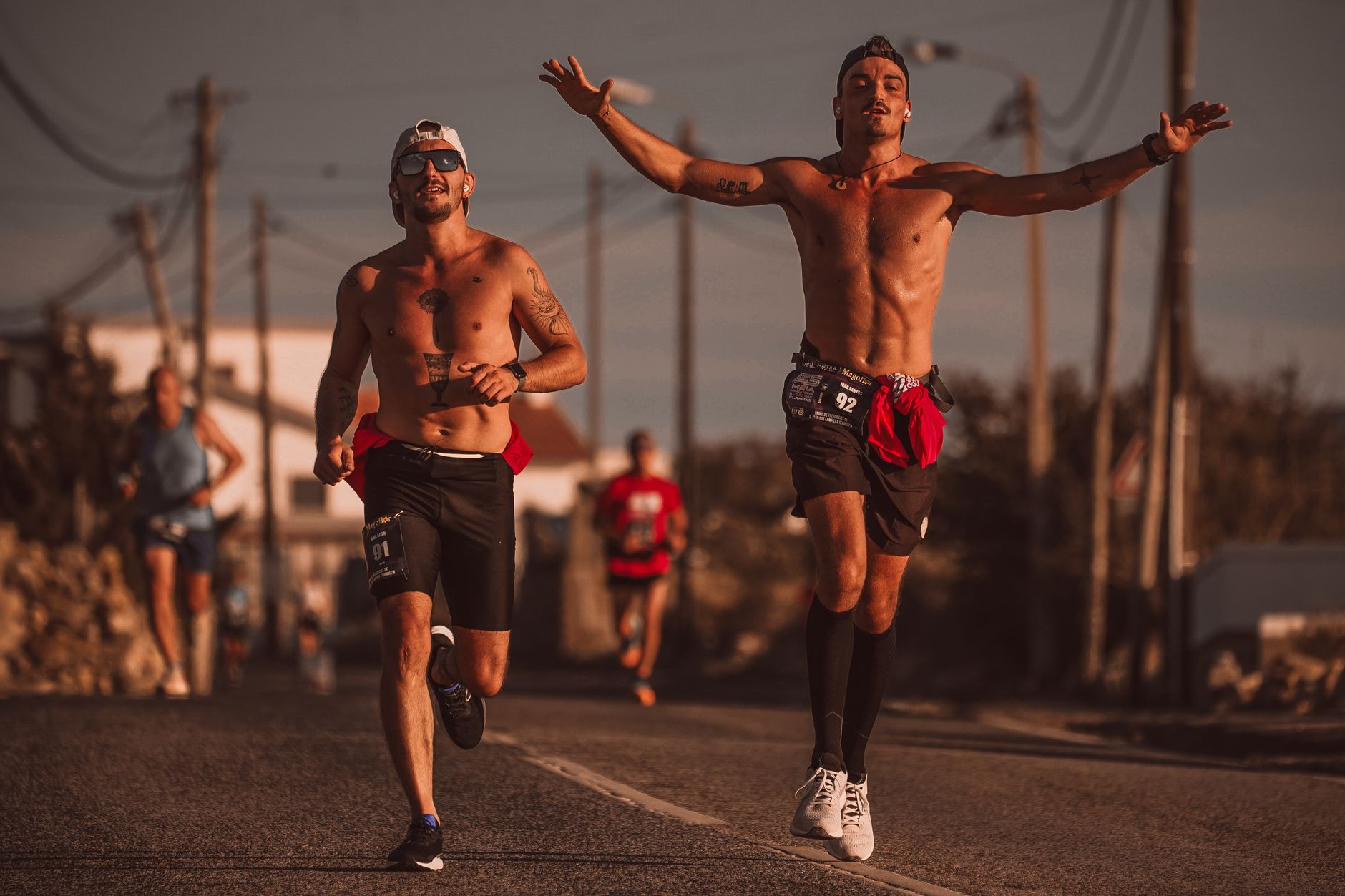 Two runners training on an urban road in daylight