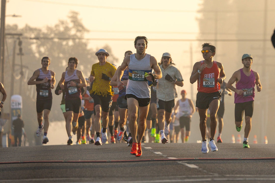 Group of runners participating in a marathon during early morning light.