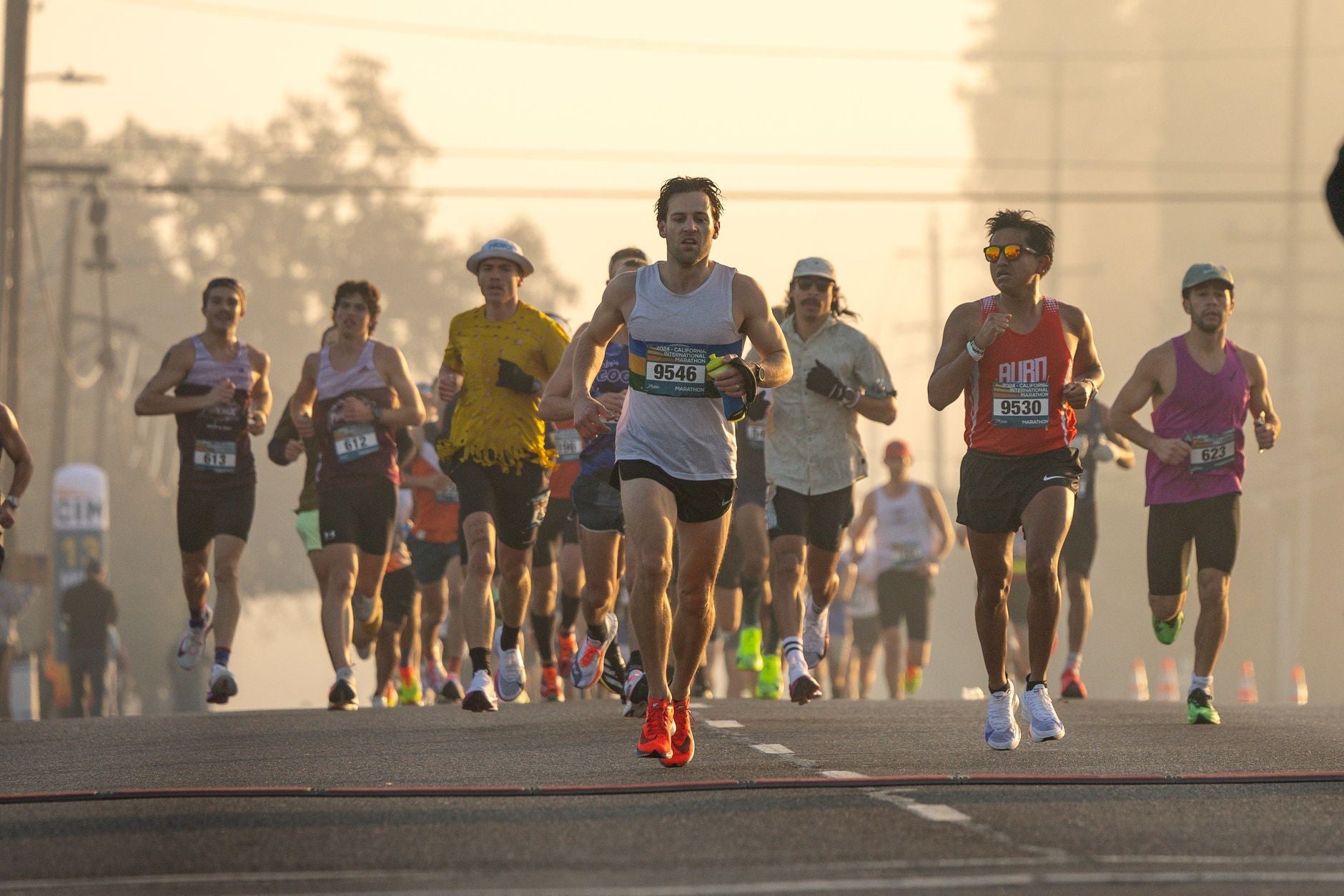 Group of runners participating in a marathon during early morning light.