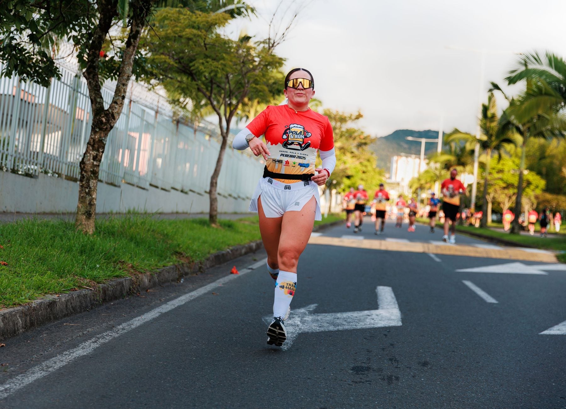 Woman running in a vibrant marathon event, showcasing determination and fitness outdoors.